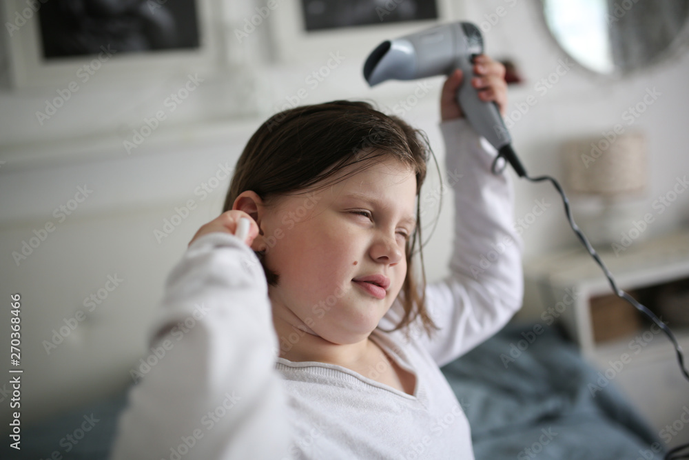 Girl, 8 years old dries her hair with hair dryer Girl, 8 years old dries her hair with hair dryer