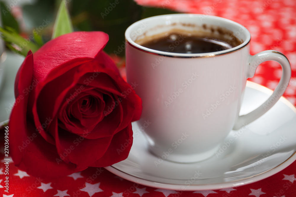 Obraz premium A cup of coffee with red rose