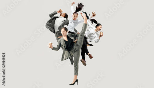 Let's start with aroma coffee. Happy office workers jumping and dancing in casual clothes or suit with hot tasty drinks isolated on studio background. Business, start-up, working open-space concept.