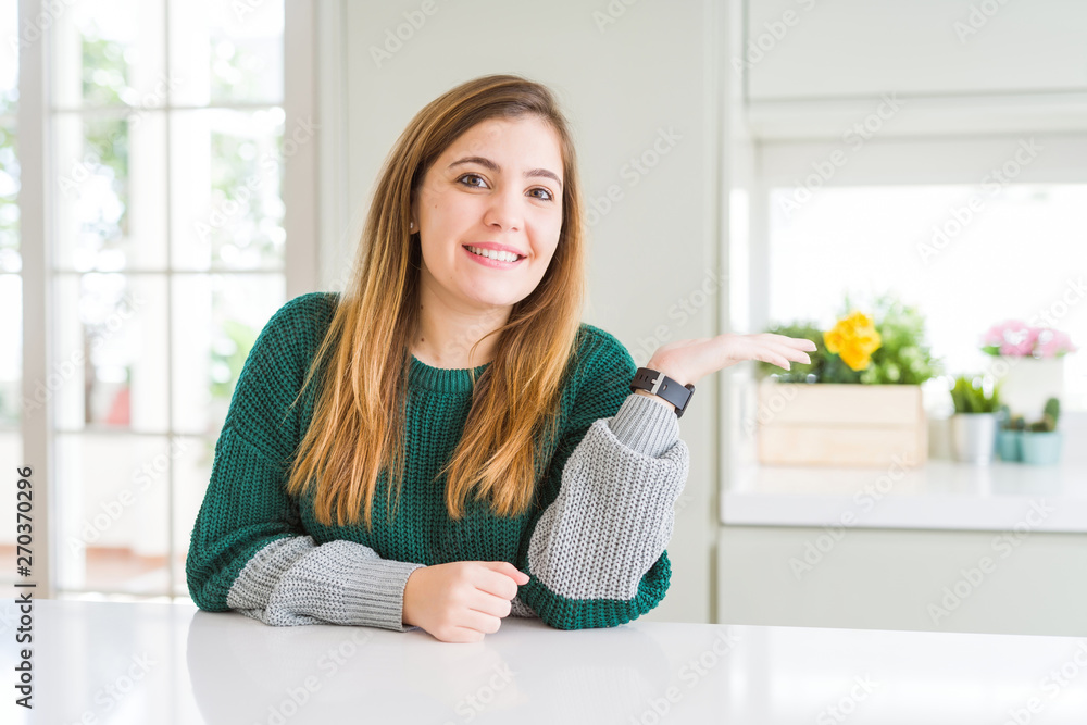 Young beautiful plus size woman wearing casual striped sweater smiling cheerful presenting and pointing with palm of hand looking at the camera. Young beautiful plus size woman wearing casual striped sweater smiling cheerful presenting and pointing with palm of hand looking at the camera.