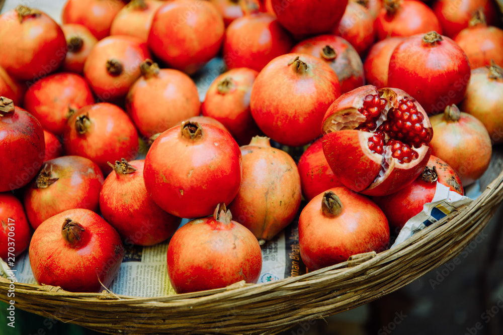 a basket full of pomegranates standing on Goa market a basket full of pomegranates standing on Goa market