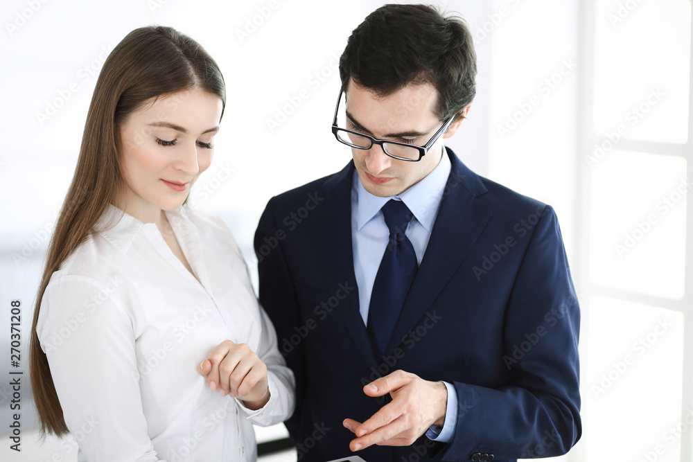 Businessmen and woman using tablet computer in modern office. Colleagues or company managers at workplace. Partners discussing contract. Business concept Businessmen and woman using tablet computer in modern office. Colleagues or company managers at workplace. Partners discussing contract. Business concept