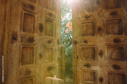 Tableau sur toile Sunlight coming out through the wooden doors ajar on Goa