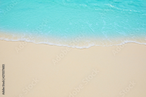 Soft waves of blue sea on the Maldives beach for the background. © chatchawan