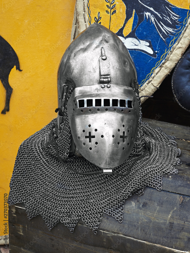 Medieval knight's helmet with chain mail on a wooden box Medieval knight's helmet with chain mail on a wooden box