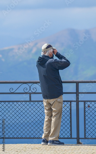 man looking throw his binoculars
