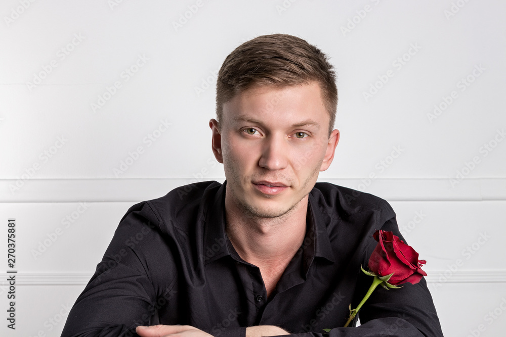 Handsome man wearing black shirt holding a rose and getting ready romantic date Handsome man wearing black shirt holding a rose and getting ready romantic date