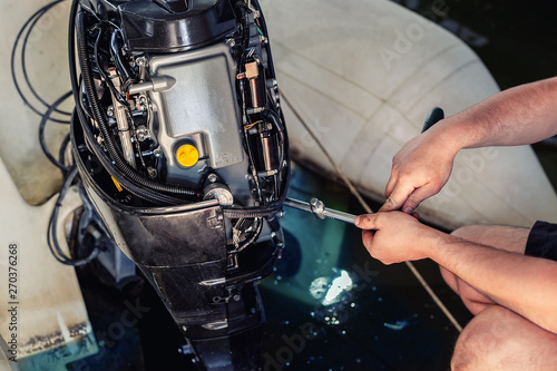 Konstfotografi mechanic repairing inflatable motorboat engine at boat garage