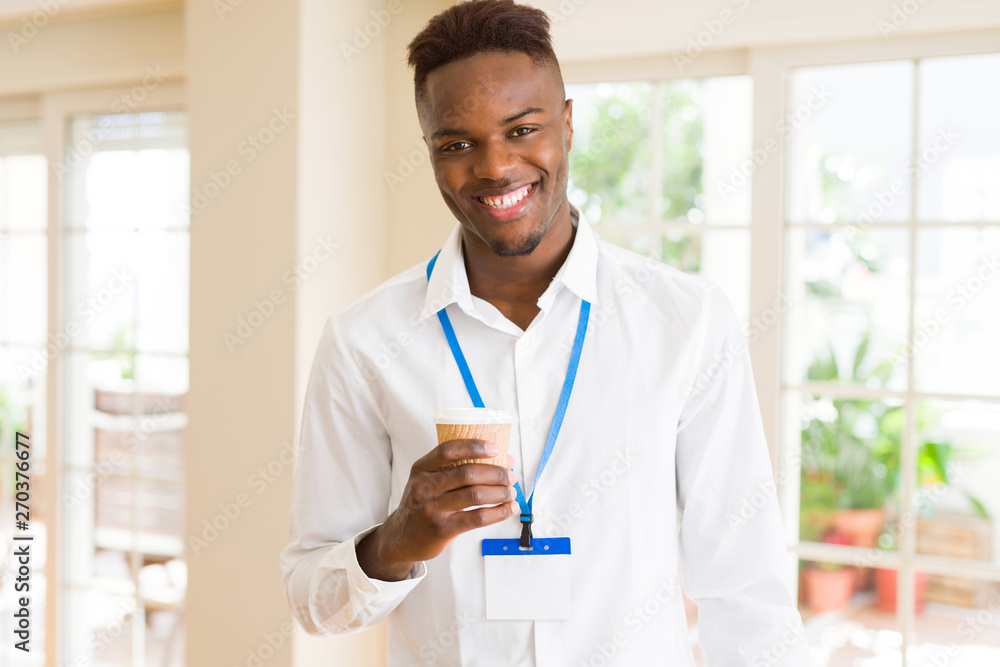 African american business man waring ID card and drinking a coffe in a take away paper cup African american business man waring ID card and drinking a coffe in a take away paper cup