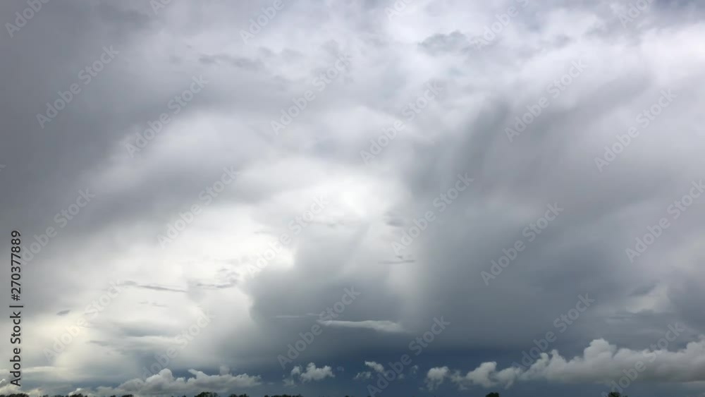 Epic gloomy storm clouds moving fast over dark blue sky background. 4K