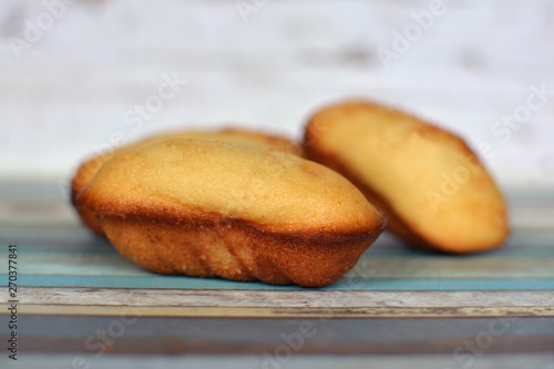 Sall traditional French Madeleine cakes on wooden background