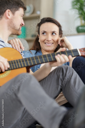 happy family playing guitar in living room
