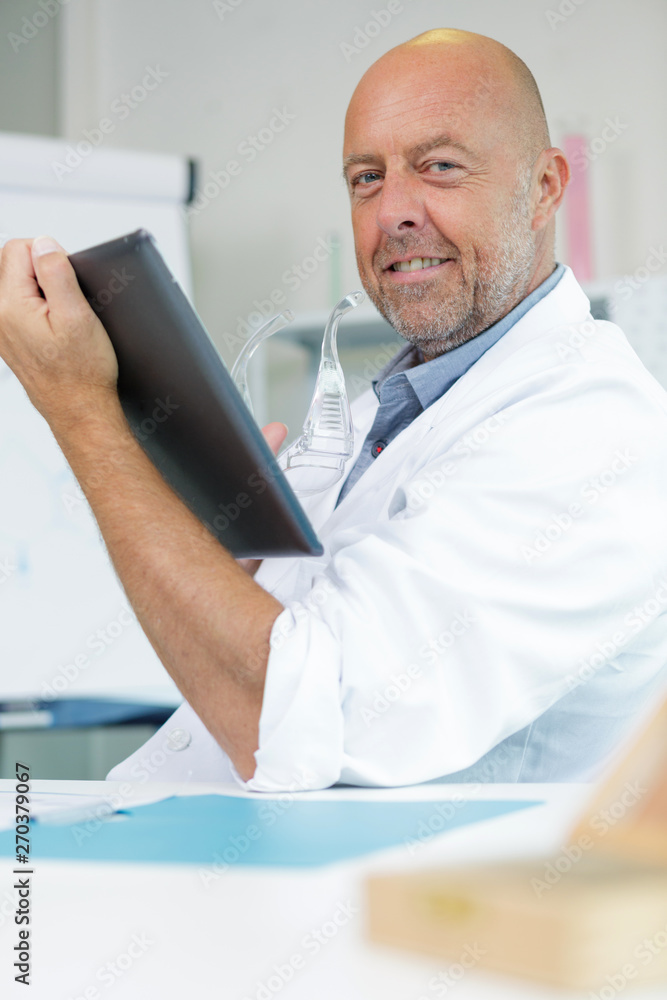 doctor looking at camera while tolding a tablet