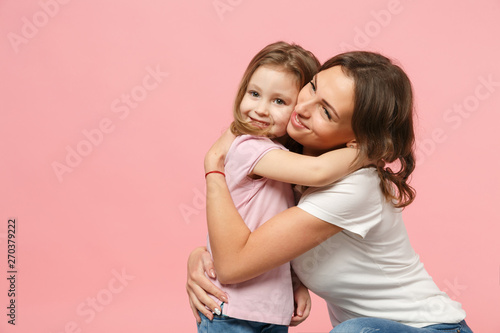 Woman in light clothes have fun with cute child baby girl. Mother, little kid daughter isolated on pastel pink wall background, studio portrait. Mother's Day, love family, parenthood childhood concept