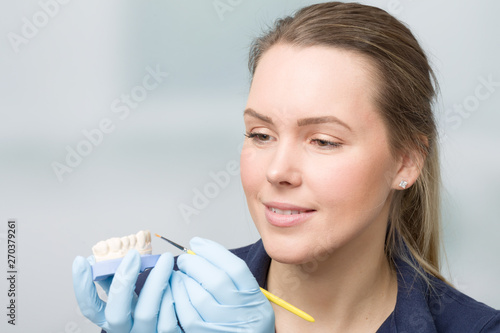 female dental technician working on artificial dention photo