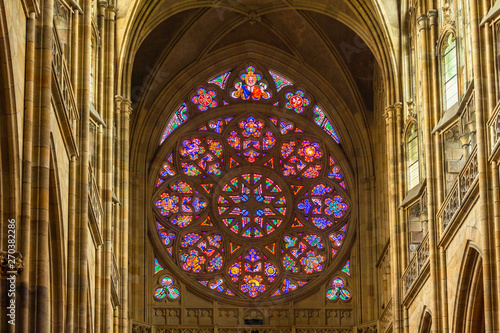 Prague, Czech Republic-February 01, 2019. Stained-glass window of main West entrance from inside the St. Vitus Cathedral. The Rose Window depicts scenes from the Biblical story of creation.