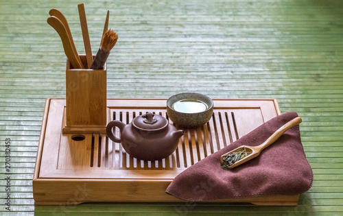 Gongfu ceremony with green Long Jing tea: teapot, cup and accessories on a chaban 