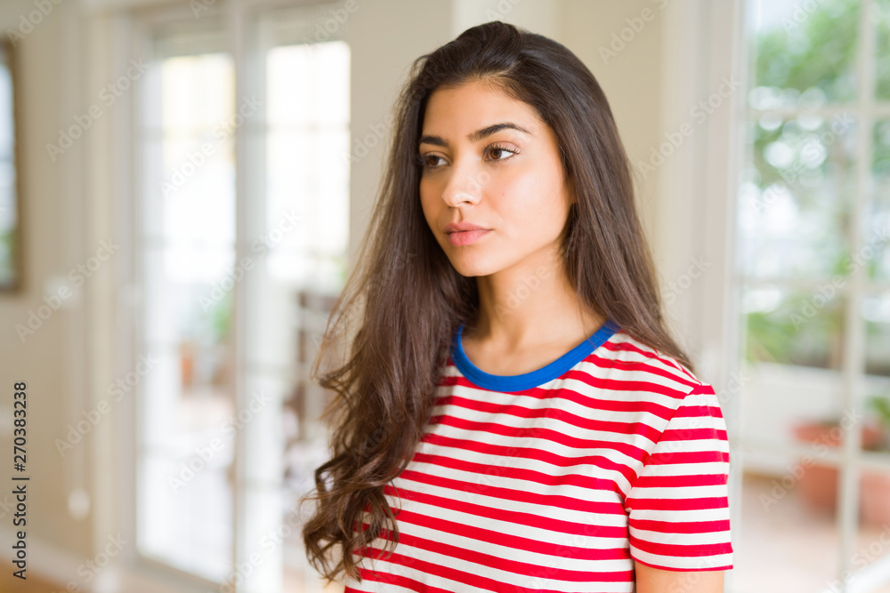 Beautiful young brunette woman looking relaxed at home