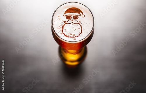 Christmas or New Year beer concept. Star symbol on beer glass foam on black table, view from above