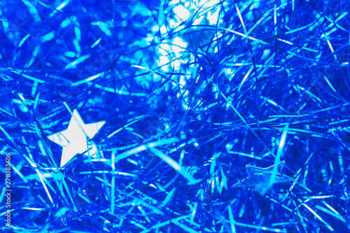 Abstract texture of Christmas decorations. Blue shiny lines with shiny stars.