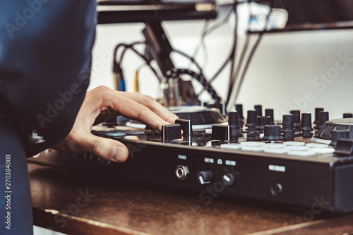 the hands of the DJ on the remote control