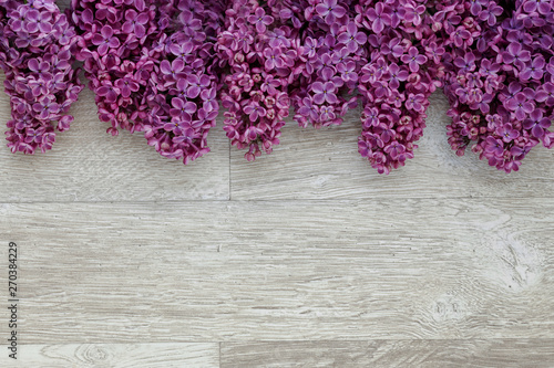 Background of lilac flowers on a wooden surface