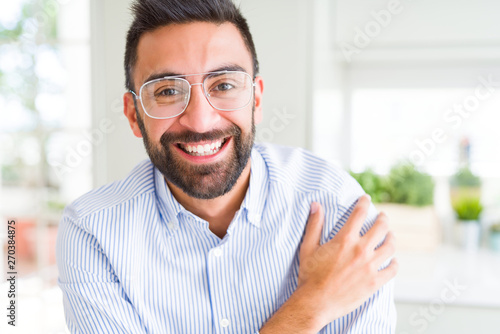 Handsome business man wearing glasses and smiling cheerful with confident smile on face