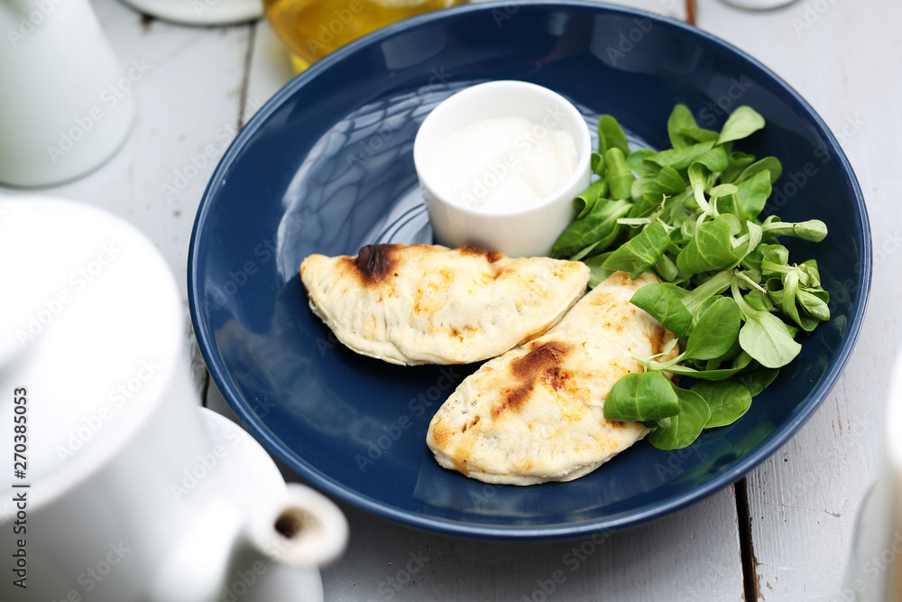 Calzone with spinach filling served with garlic sauce. Calzone with spinach filling served with garlic sauce.