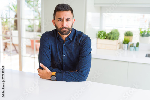 Handsome hispanic man skeptic and nervous, disapproving expression on face with crossed arms. Negative person. © Krakenimages.com
