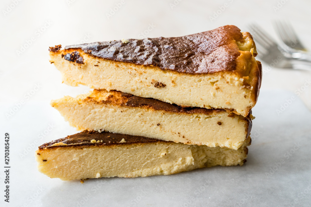 San Sebastian Cheesecake Slice on Marble Surface / Creamy Plain New York Style. San Sebastian Cheesecake Slice on Marble Surface / Creamy Plain New York Style.