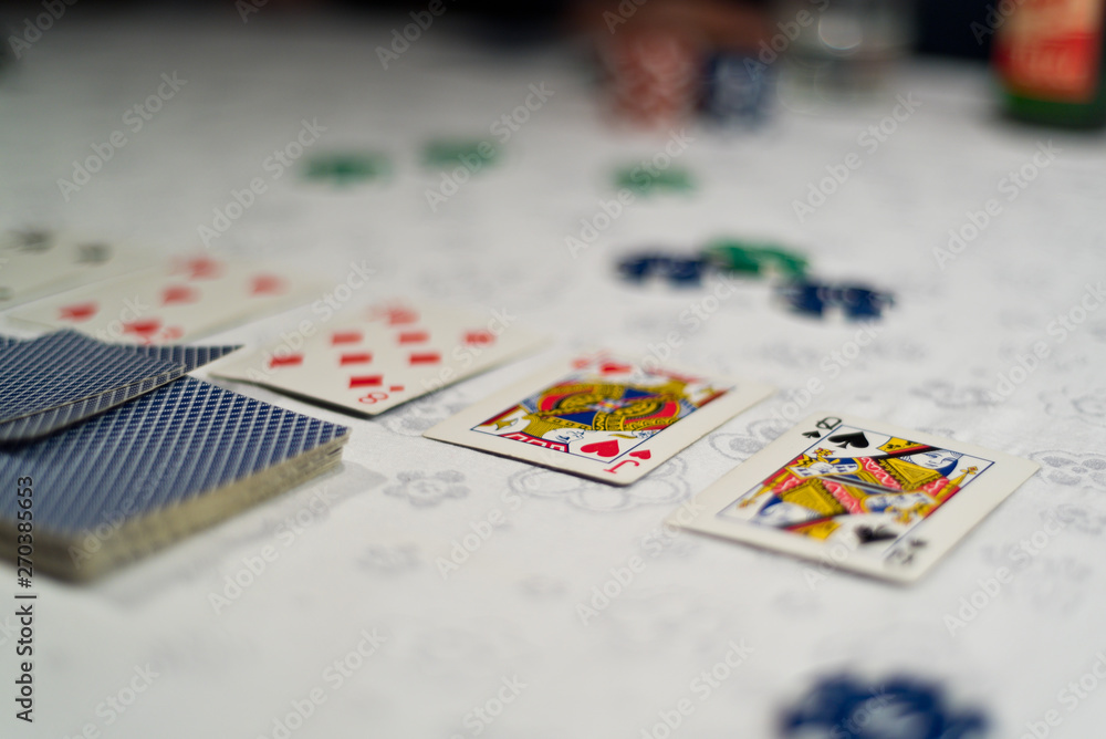 Poker community cards uncovered and chips as bets placed on a table with white tablecloth. Poker community cards uncovered and chips as bets placed on a table with white tablecloth.
