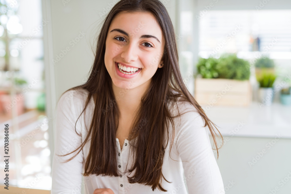 Beautiful young brunette woman smiling cheerful looking at the camera with a big smile on face showing teeth Beautiful young brunette woman smiling cheerful looking at the camera with a big smile on face showing teeth