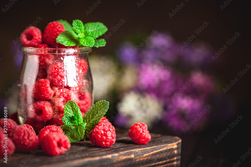 Raspberries in a Cup on a dark background. Summer and healthy food concept. Background with copy space. Selective focus. Vertical.