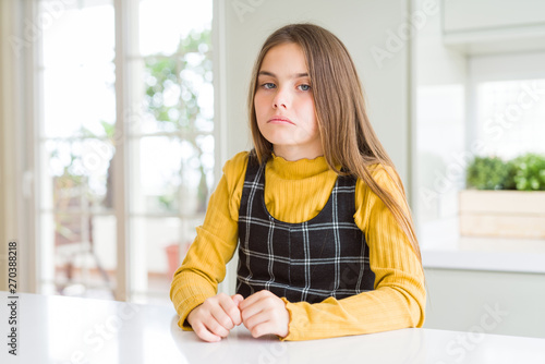 Young beautiful blonde kid girl wearing casual yellow sweater at home depressed and worry for distress, crying angry and afraid. Sad expression.