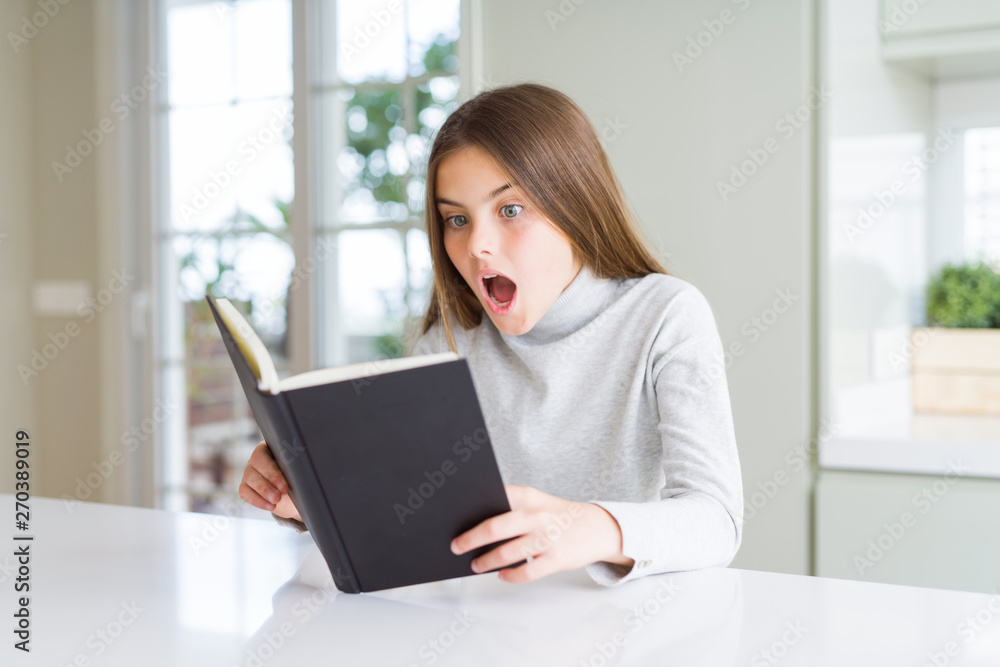 Beautiful young girl reading a book at home scared in shock with a surprise face, afraid and excited with fear expression Beautiful young girl reading a book at home scared in shock with a surprise face, afraid and excited with fear expression