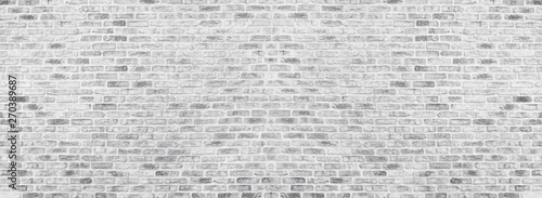 Wide white washed brick wall texture. Rough light gray brickwork. Whitewashed panoramic vintage background
