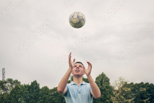 Young man tossing a soccer ball into the air