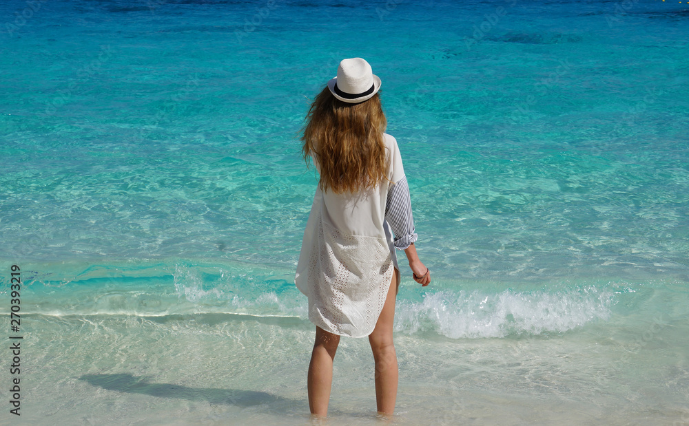Beautiful girl standing and looking at the sea Beautiful girl standing and looking at the sea