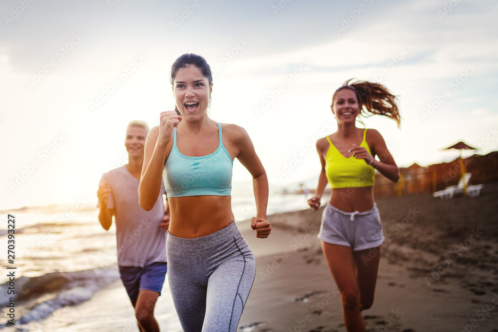Group of young friends running and exercising on the beach Group of young friends running and exercising on the beach