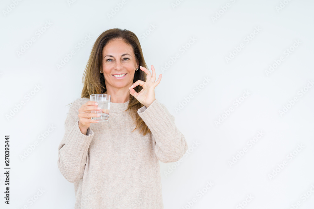 Middle age woman drinking glass of water isolated background doing ok sign with fingers, excellent symbol Middle age woman drinking glass of water isolated background doing ok sign with fingers, excellent symbol