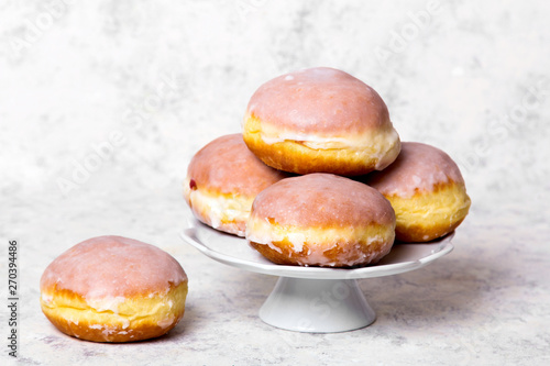 Traditional Polish donuts with frostng on light background. Tasty doughnuts with jam.