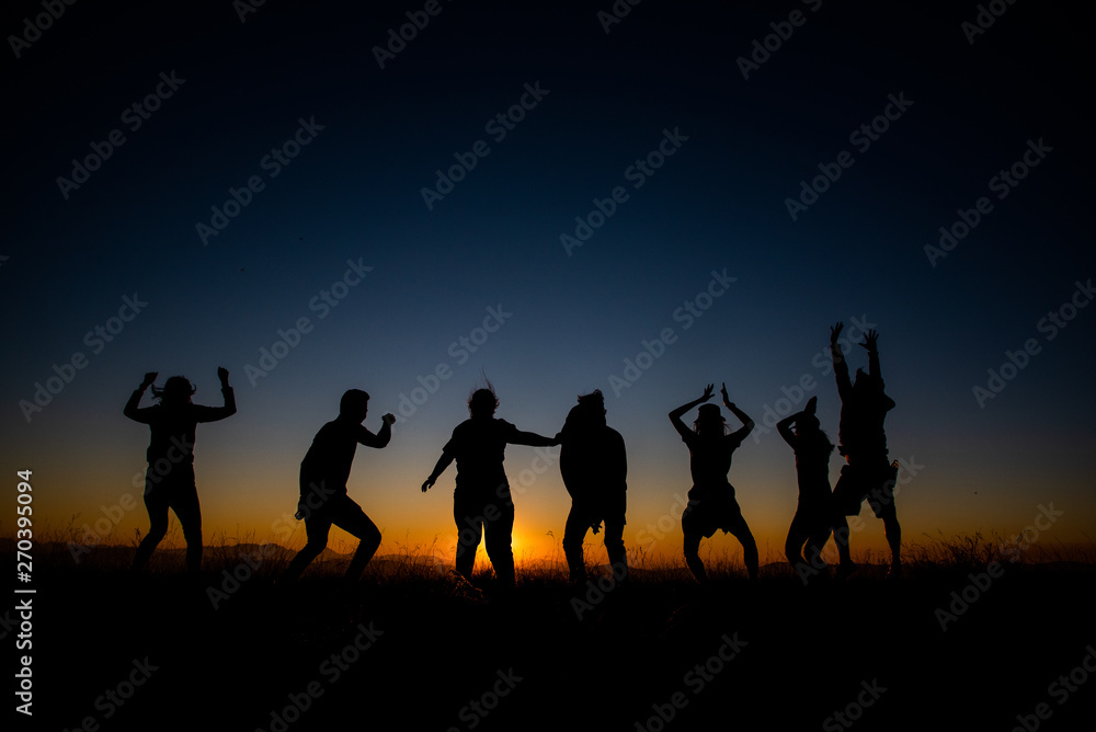 Silhouettes group of people on  mountain with sunset