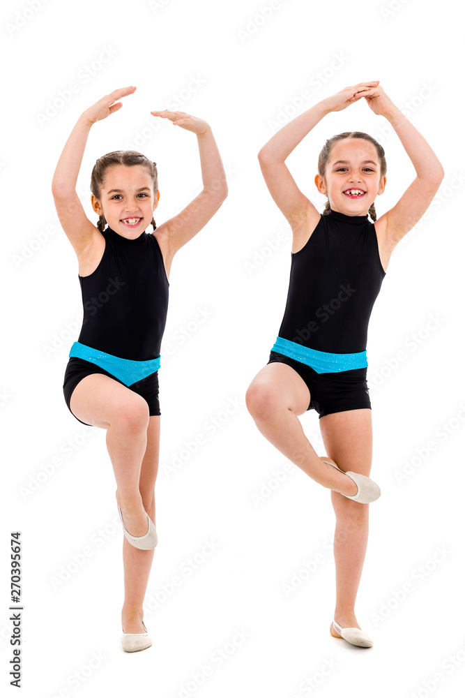 Identical twin girls practice and doing rhythmic gymnastics, white background. Identical twin girls practice and doing rhythmic gymnastics, white background.