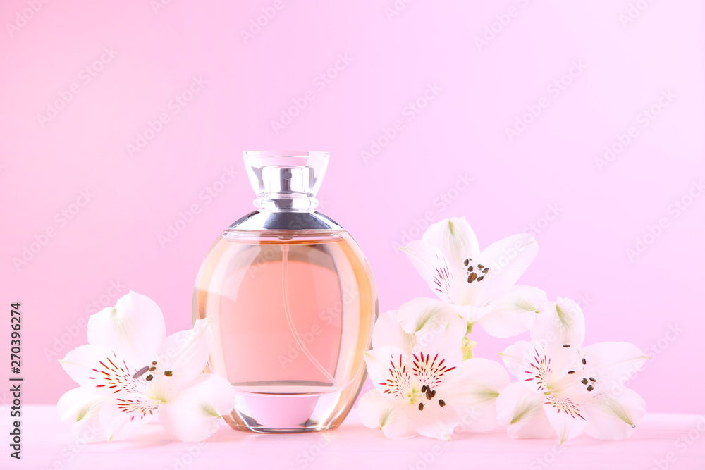 Bottle of perfume with flowers on pink background - obrazy, fototapety, plakaty 