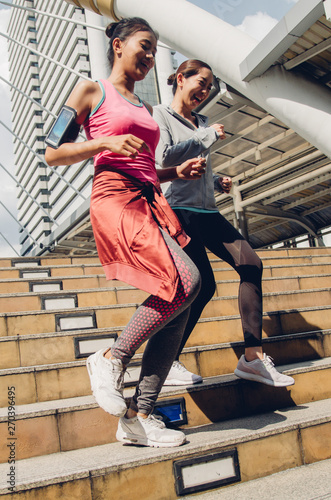 Two beautiful asian woman running in city. Sport Concept