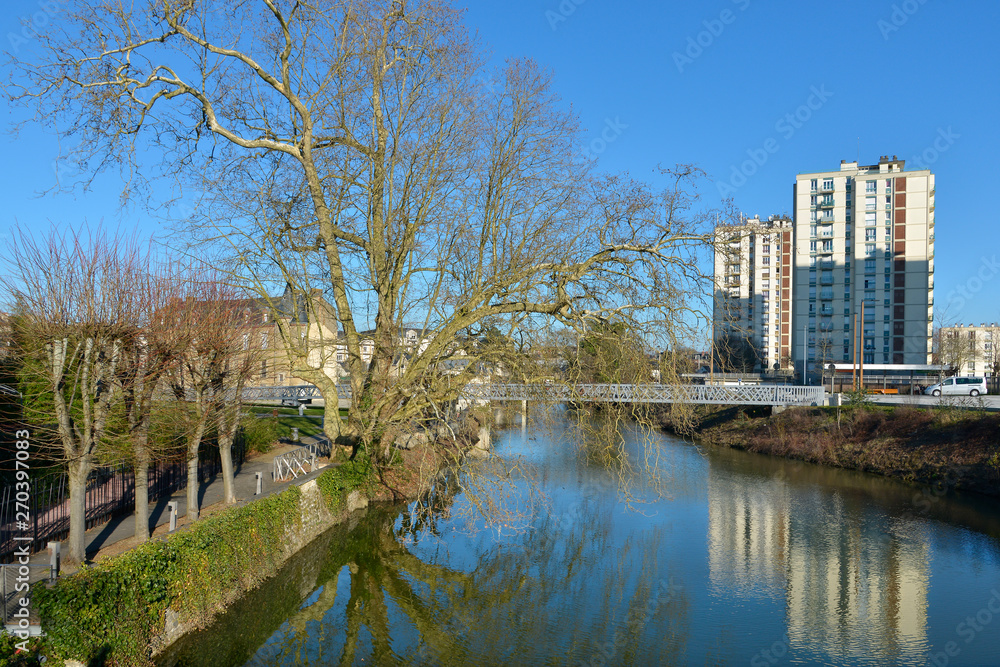 Trees and apartment blocks on the bank of river Sarthe at Alençon of the Lower Normandy region in France