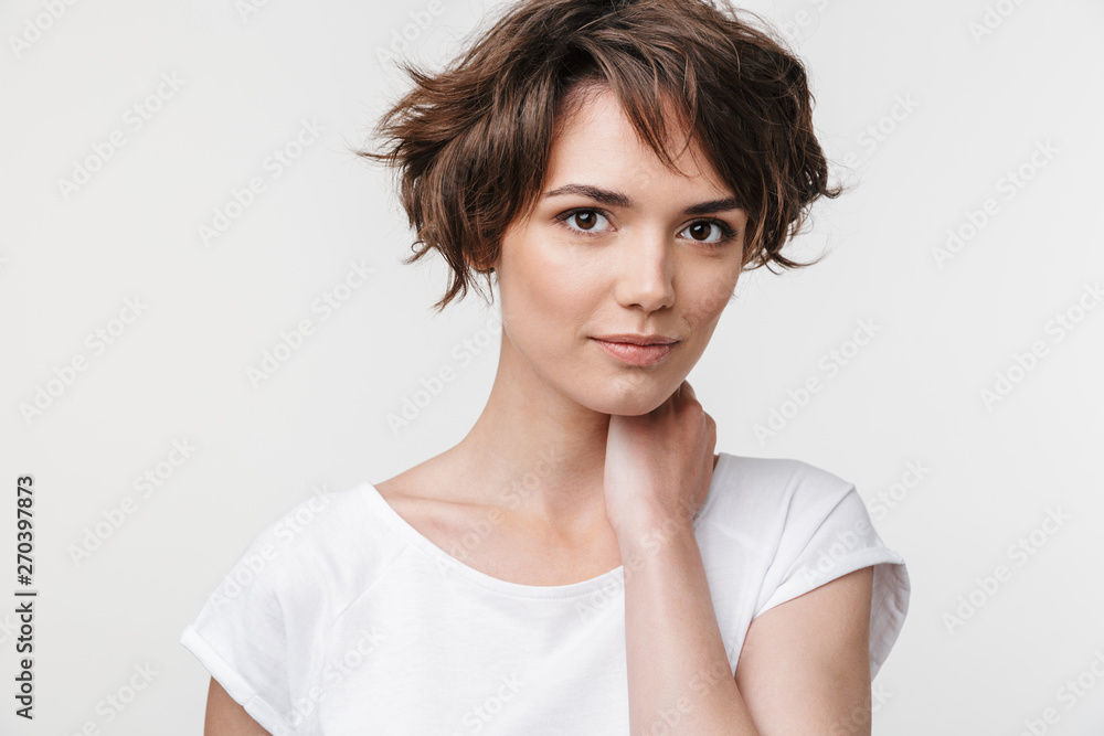 Portrait of young woman with short brown hair in basic t-shirt looking at camera Portrait of young woman with short brown hair in basic t-shirt looking at camera