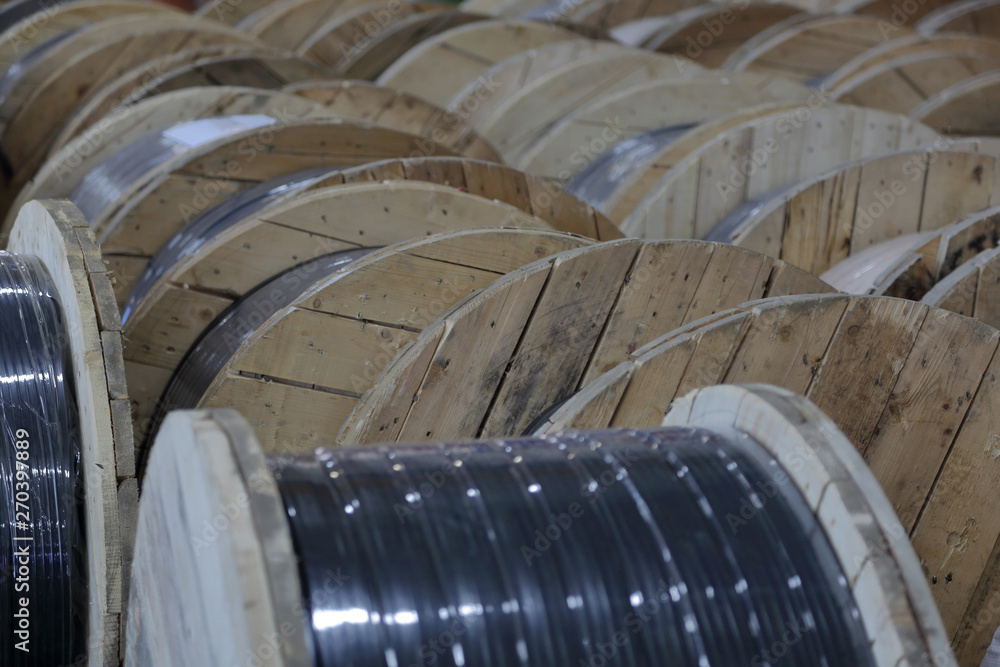 Fototapeta premium Massive wooden bobbins with wound electric cable