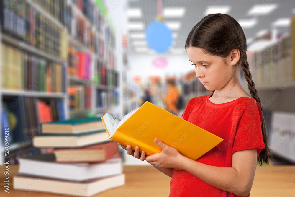 Cute little schoolgirl in glasses with books on background Cute little schoolgirl in glasses with books on background