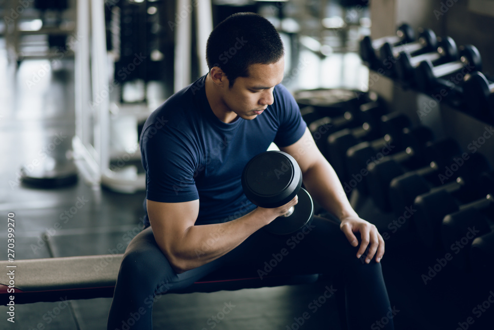 Young muscular lifting weights at gym Young muscular lifting weights at gym